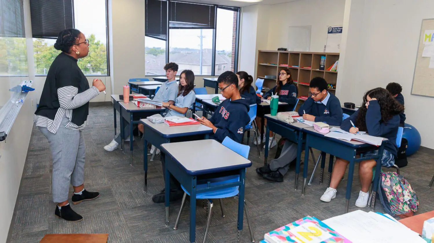 DIS High School students listening attentively to a teacher in class.