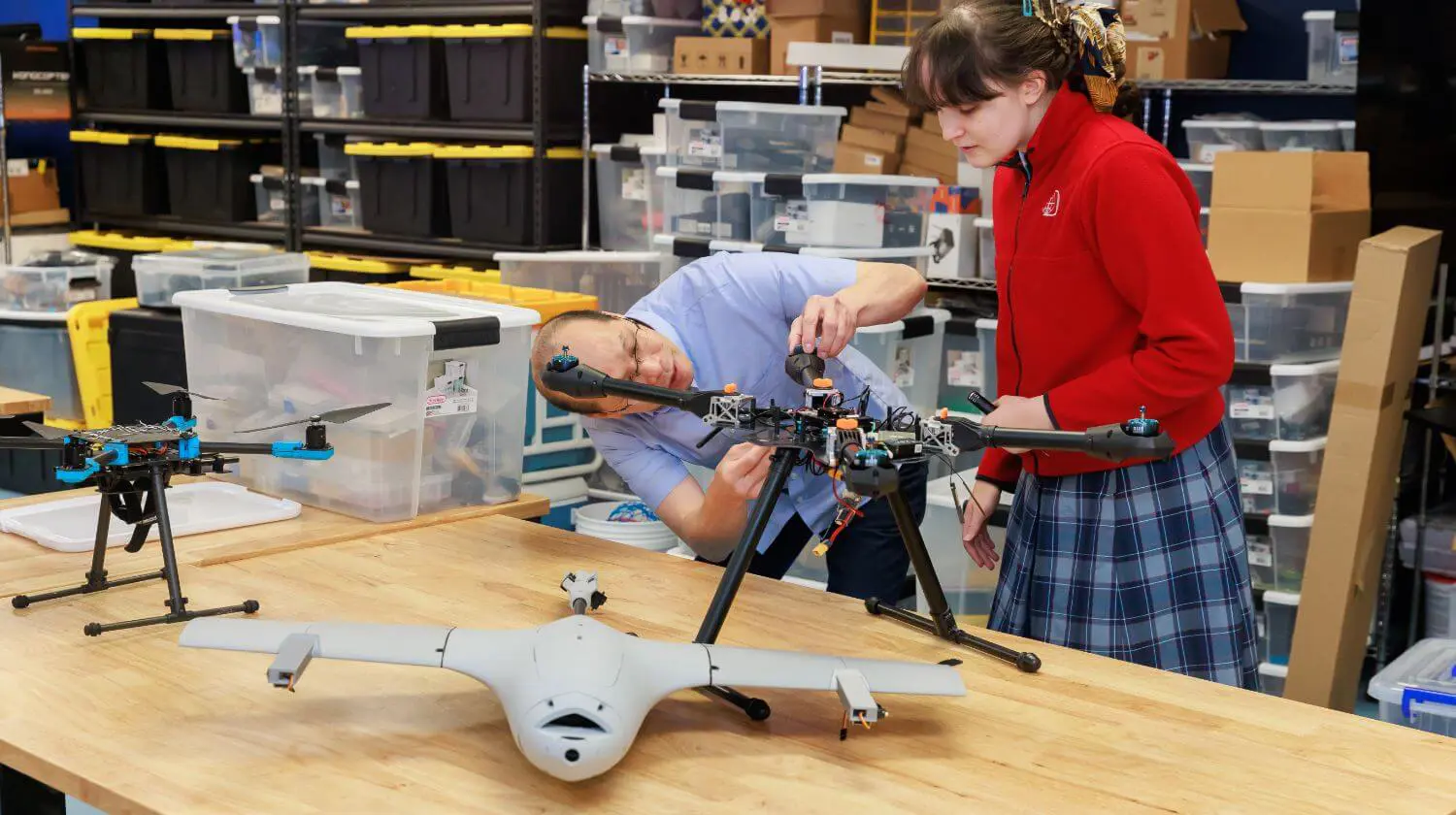 DIS High School student works on a drone with the help of a teacher.