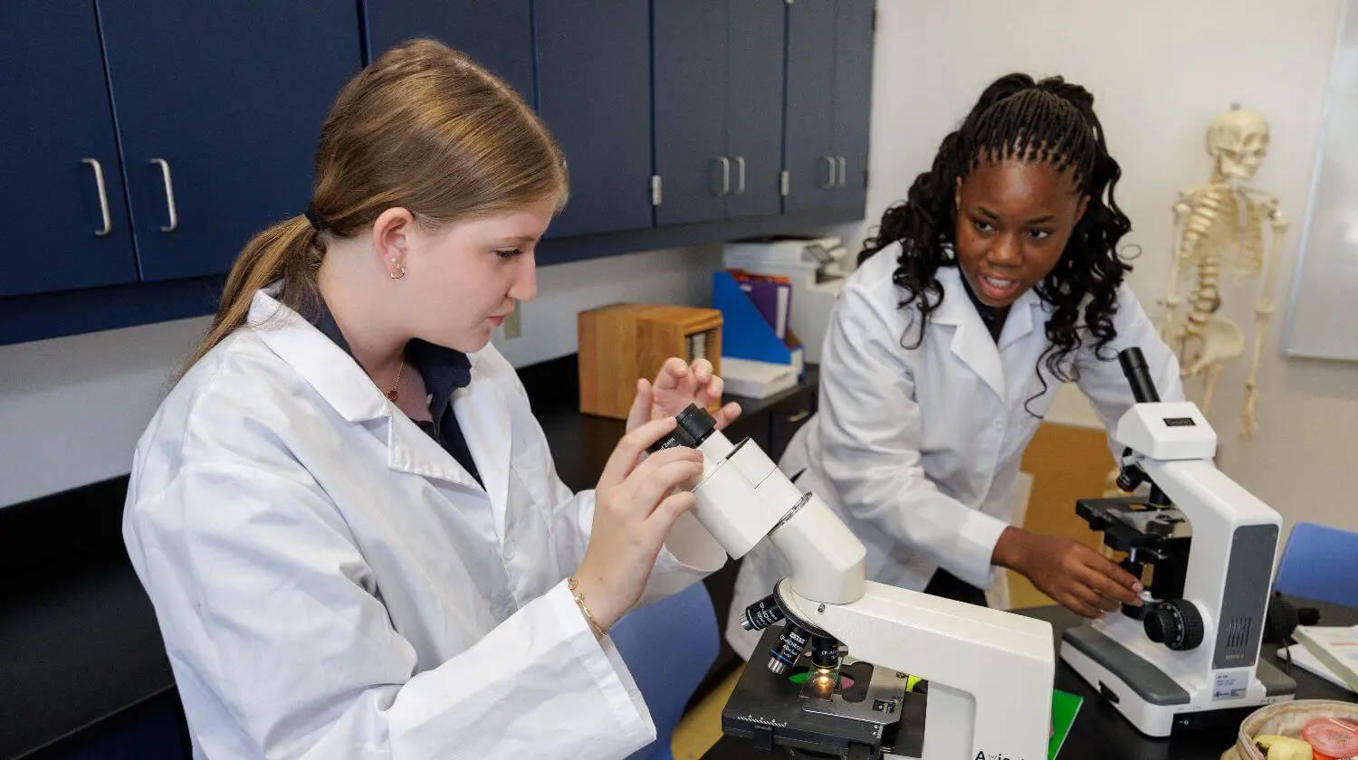 DIS High School students working with microscopes during a science class.