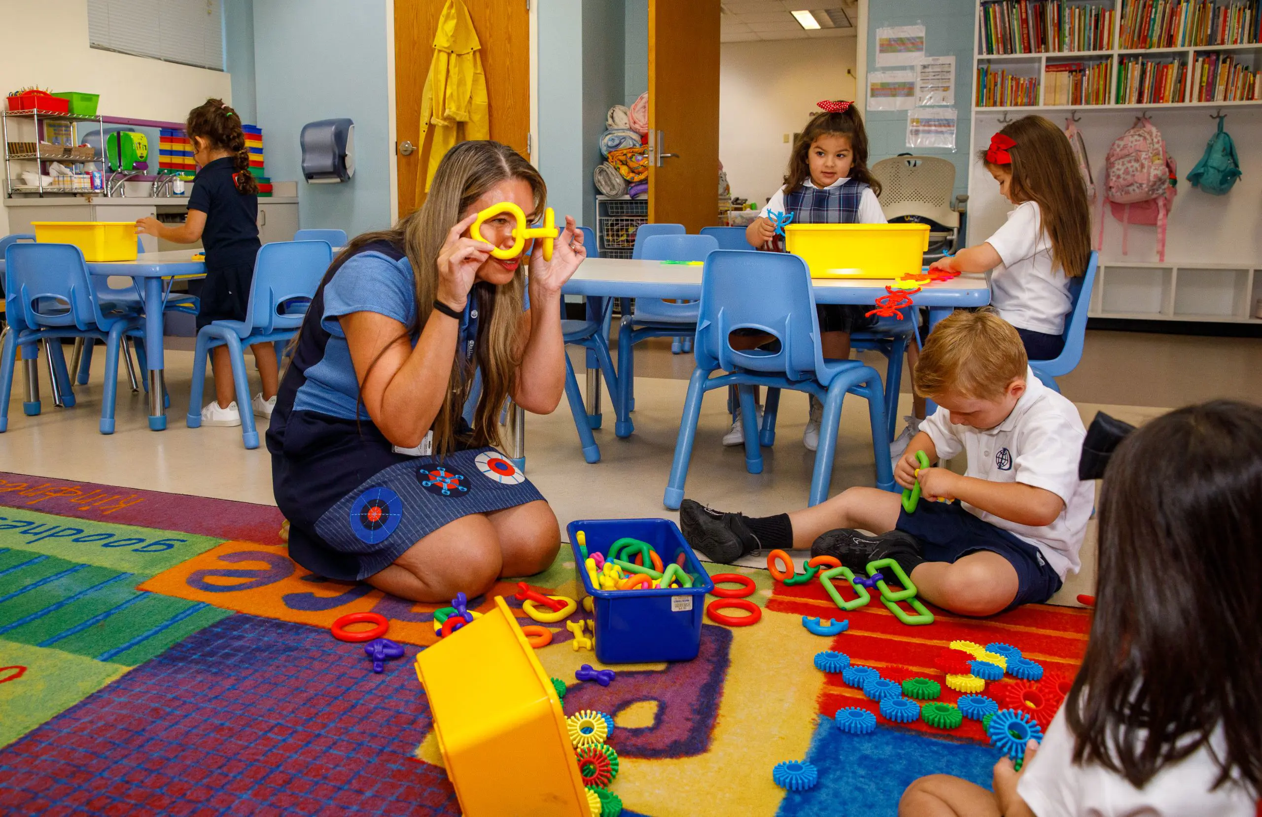 DIS elementary school teacher and students playing with a toy construction set.