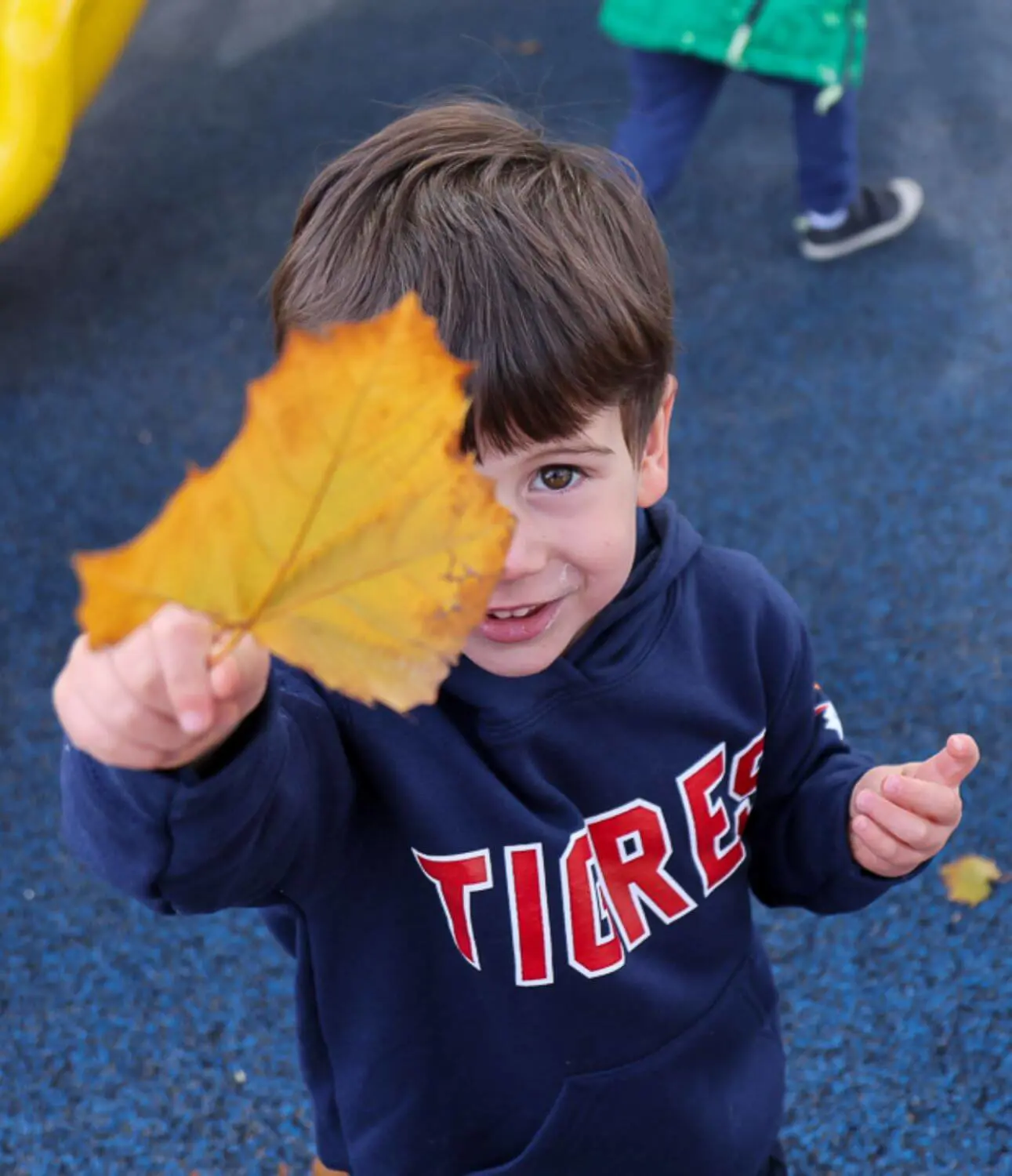 DIS Early Childhood student holding a leaf in the playground.
