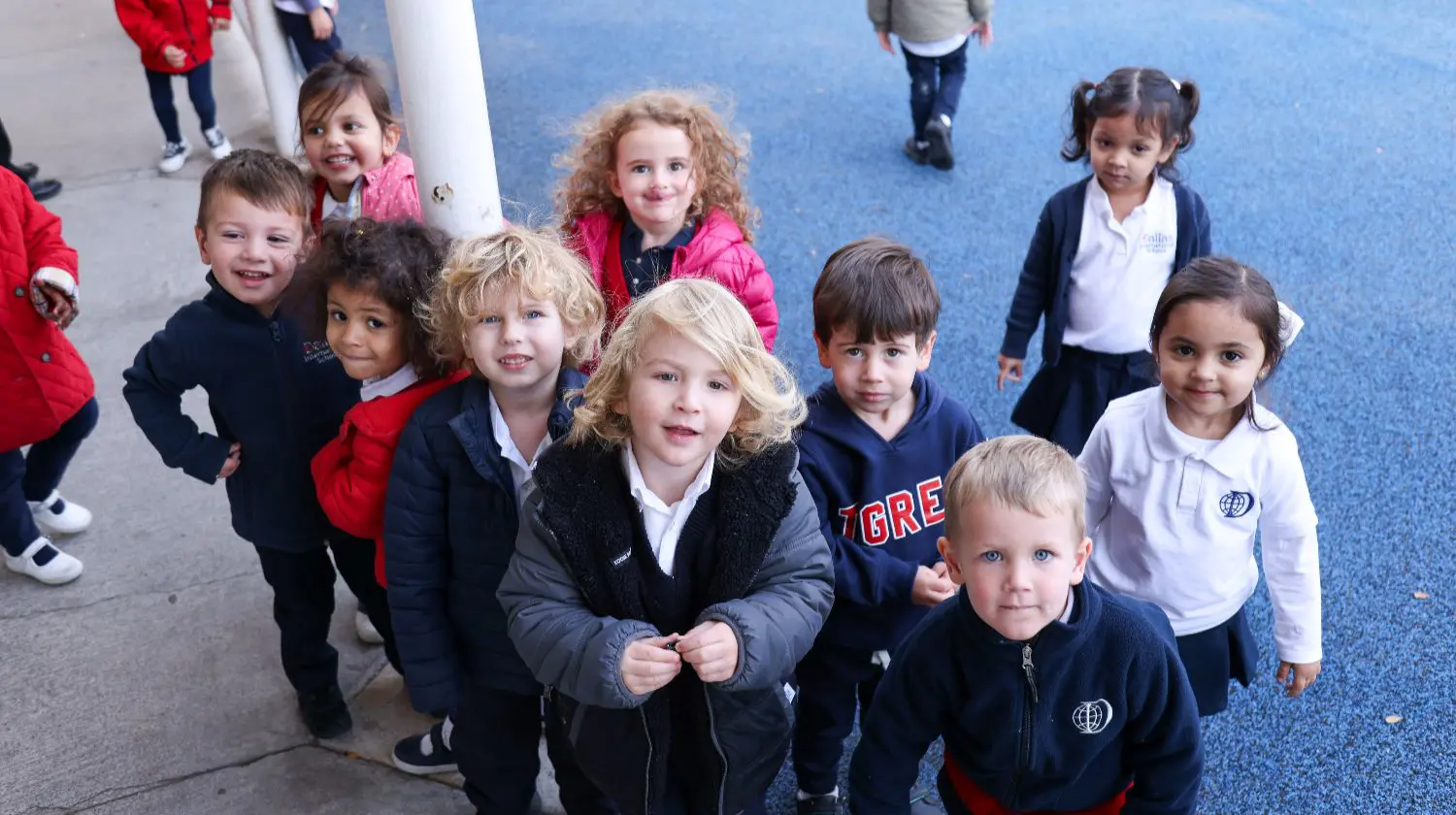 DIS elementary students smiling while in the playground.