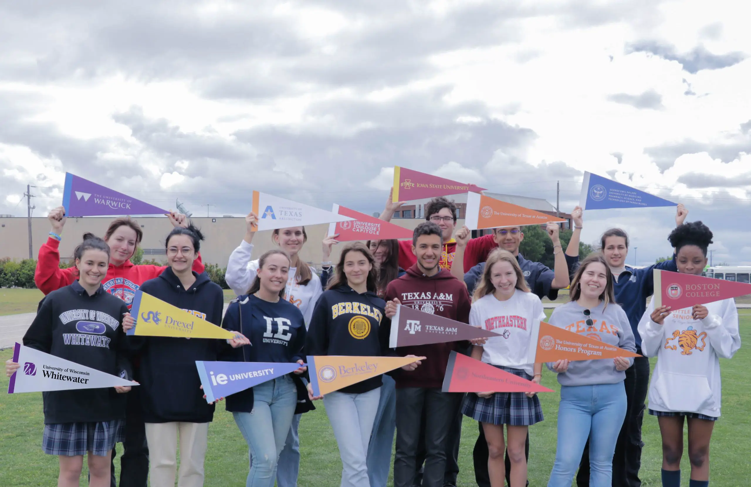 DIS High School students posing for a photograph with college pennants.