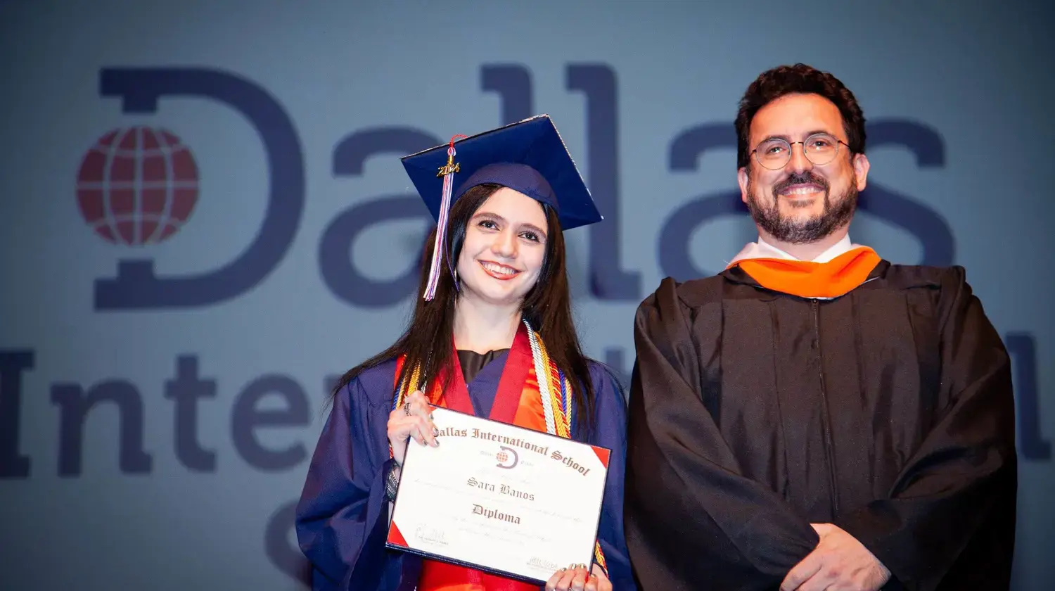 Head of School Jacques Weber poses for a photograph with a student at graduation.